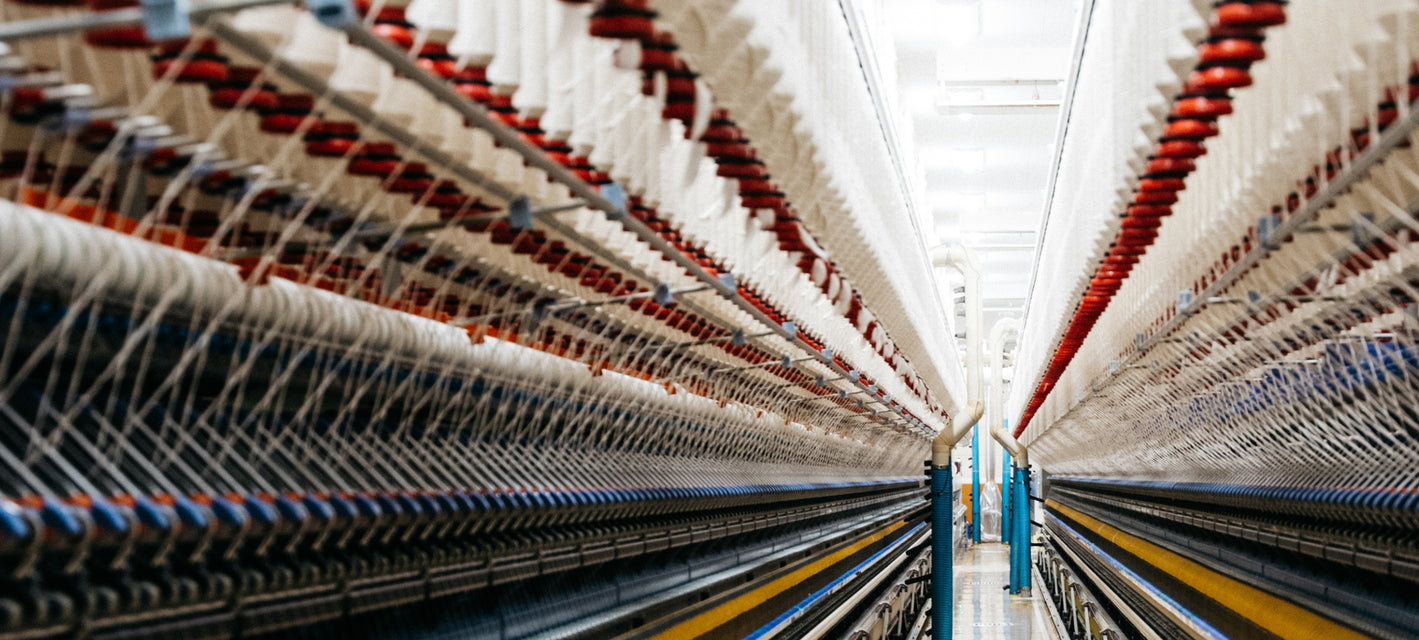 Textile factory with large spools of thread in a warehouse setting